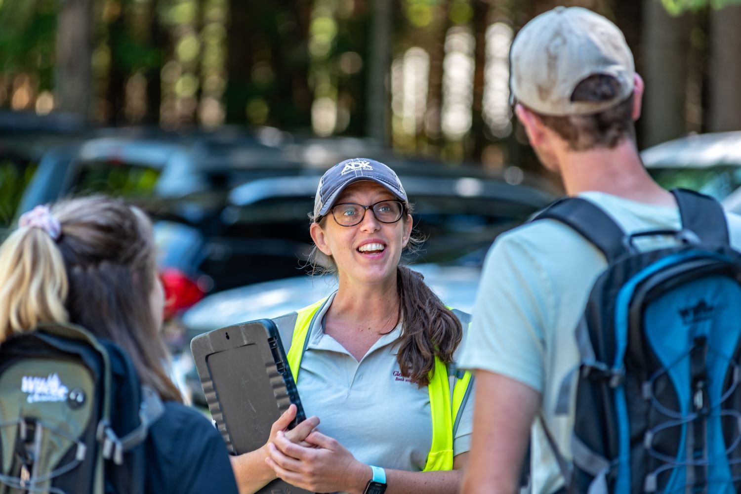 ADK trailhead steward speaks to two guests at Heart Lake Program Center