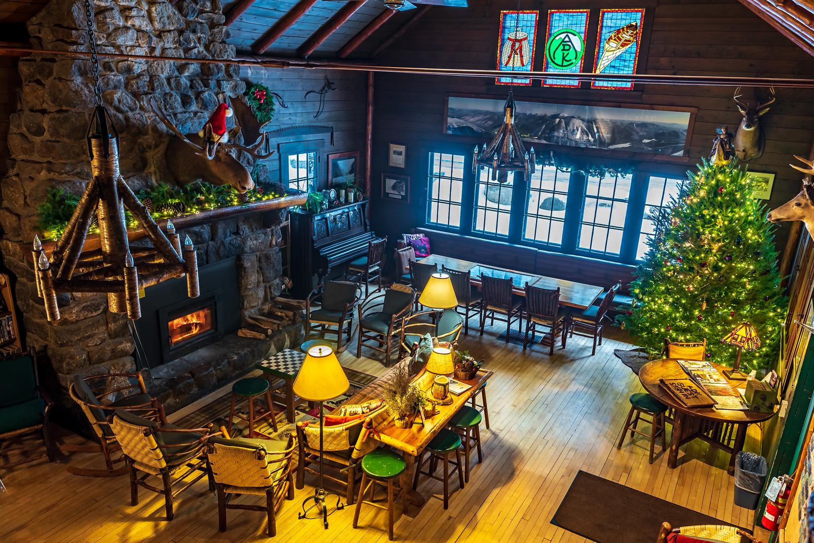 a large room inside a lodge with a fireplace and seating